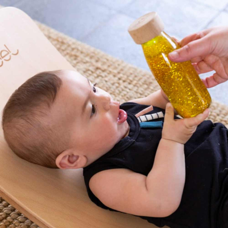 bébé avec une bouteille sensorielle curcuma