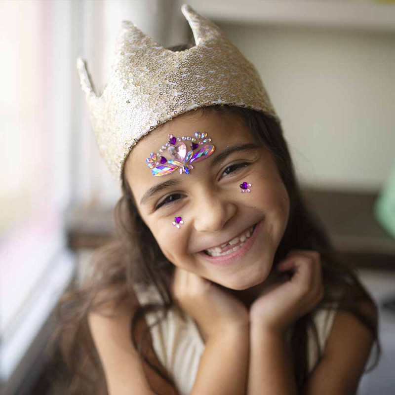 Petite fille souriante avec couronne or étincelante