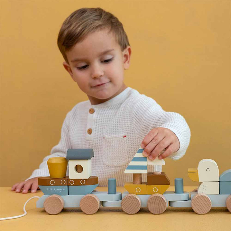 jeune garçon qui s'amuse avec les formes en bois du train