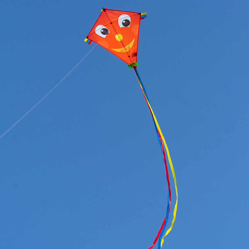 Cerf-volant rouge avec tête souriante pour les enfants