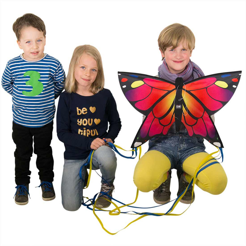 3 enfants avec le cerf-volant en forme de papillon rose