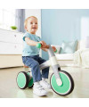 Enfant avec son premier tricycle vert pastel de Hape
