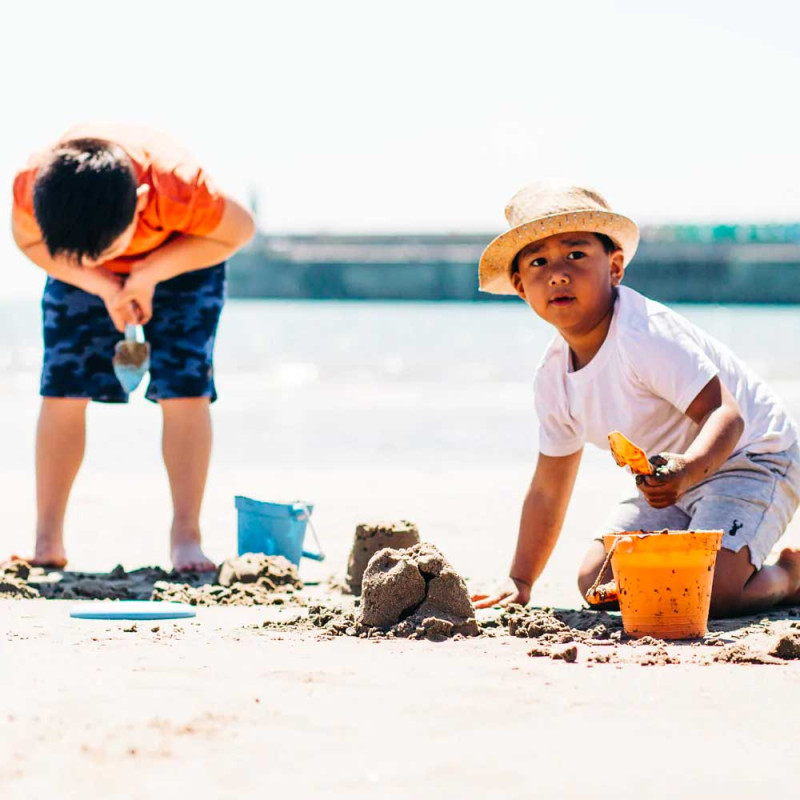 Les enfants qui jouent avec les jouets de plage écologiques de Bigjigs