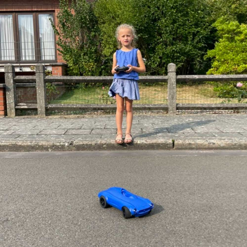 petite fille qui joue avec la voiture bleue Kidycar