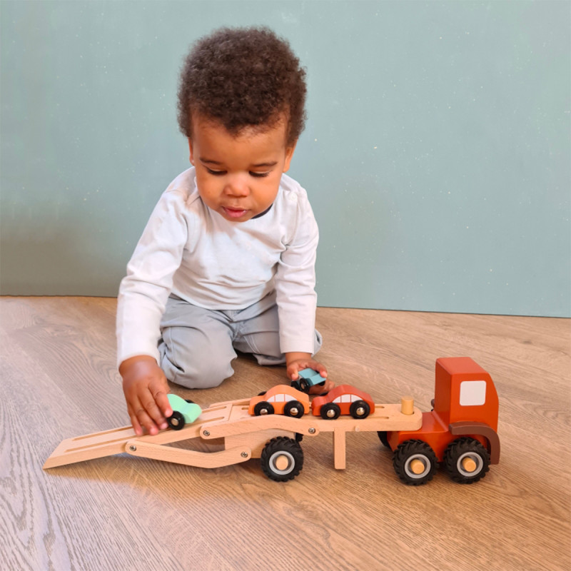 Image enfant jouant au camion transporteur de voitures en bois