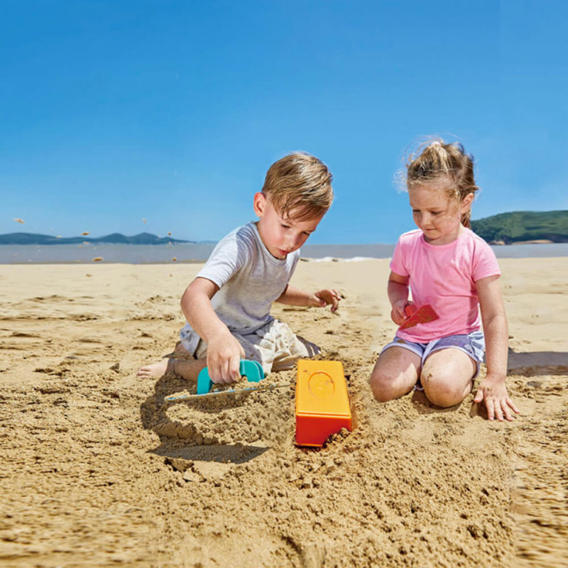 enfants qui s'amusent dans le sable avec jouet Hape