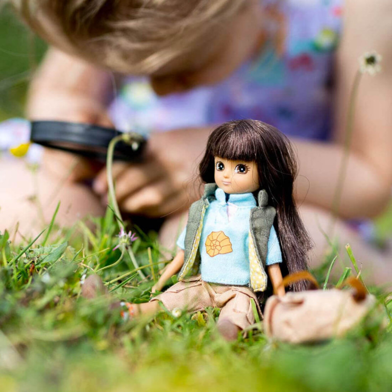 petite fille qui s'amuse à la recherche de fossiles avec sa poupée Lottie.