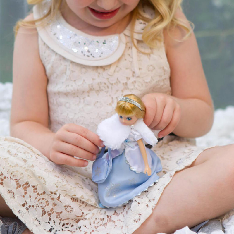 Petite fille qui joue avec la poupée Lottie reine des neiges.
