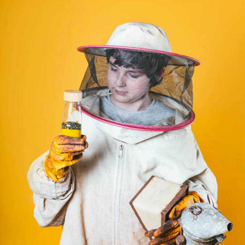 Garçon avec bouteille sensorielle Petit Boum sur le thème des abeilles