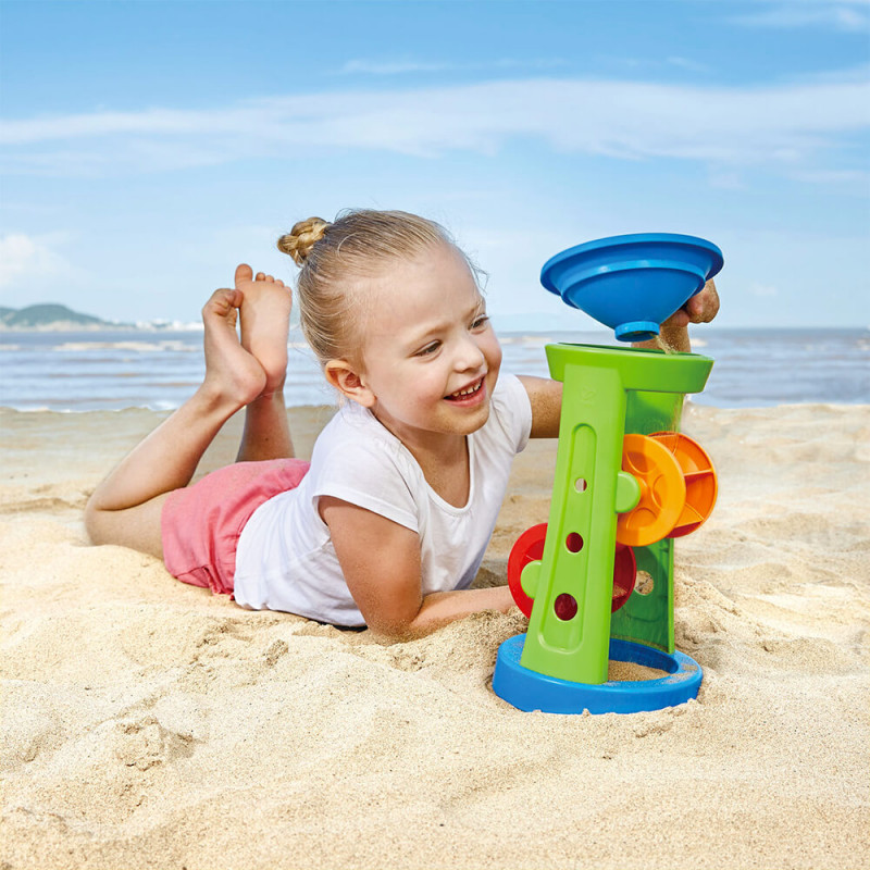 Petite fille qui joue avec le moulin à sable/eau