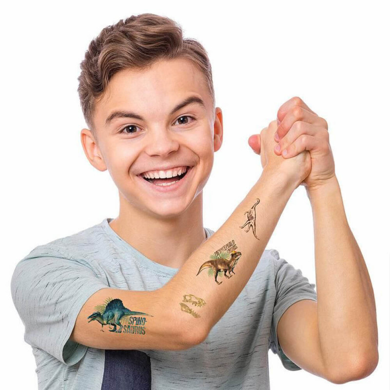 Enfant avec des tatoos éphémères de dino
