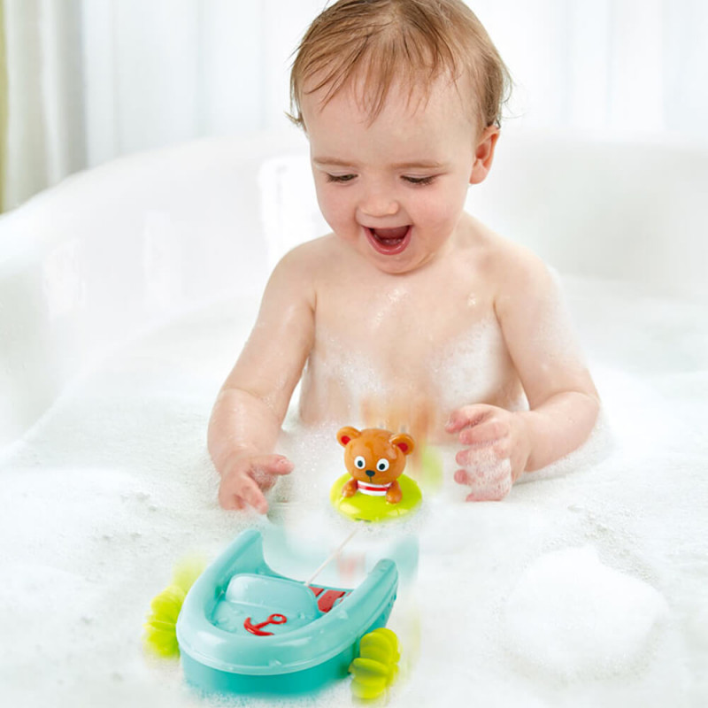 bébé dans le bain avec son jouet bateau et sa bouée